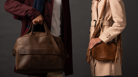 Casual stroll with a Rare Klub bag, perfect for everyday use, featuring a partial view of a stylish couple in autumn outfits holding leather bags against a black background.